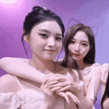 two girls posing for a picture with one wearing a cat ear
