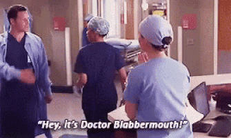 a group of doctors are standing in a hospital room talking to each other and one of them is talking about doctor blabbermouth .