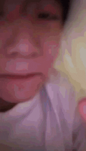 a close up of a person 's face with a white shirt on