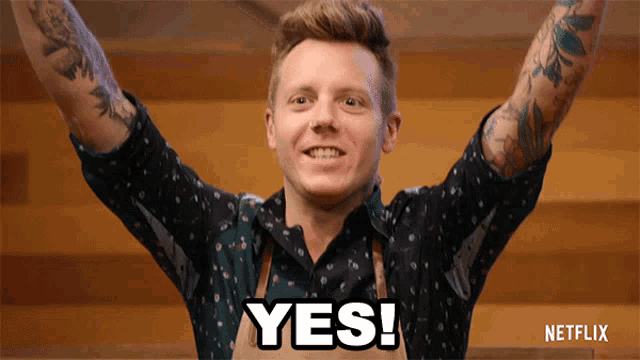 a man with his arms in the air and the word yes written on his chest