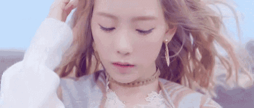 a close up of a woman with long blonde hair wearing a choker .