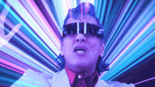 a man wearing sunglasses and a white suit is standing in front of a purple and blue light .