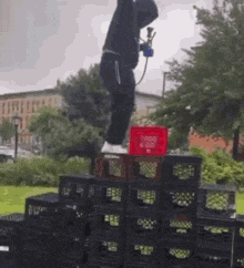 a man is jumping over a stack of milk crates in a park .