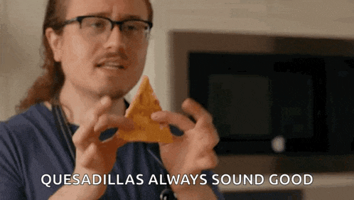 a man with glasses is holding a tortilla chip and the words quesadillas always sound good are visible