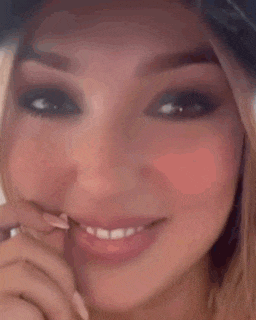 a close up of a woman 's face with a hat on and a smile on her face .
