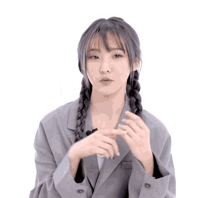a woman with braids and a gray jacket is making a funny face