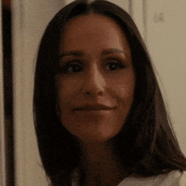 a woman with long dark hair smiles for the camera