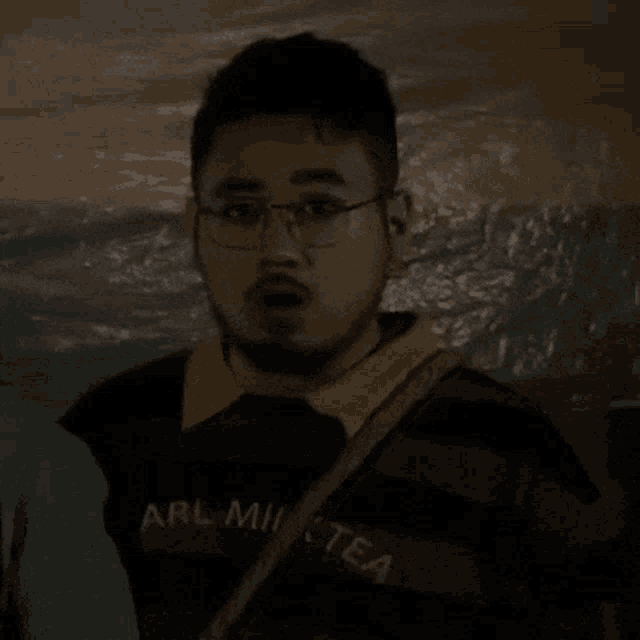 a man is wearing glasses and a shirt that says arl milk tea