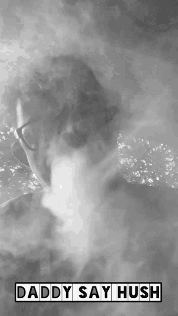 a black and white photo of a man smoking a cigarette with the words daddy say hush above him