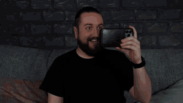 a man in a black shirt is looking at a white electrical outlet on the wall