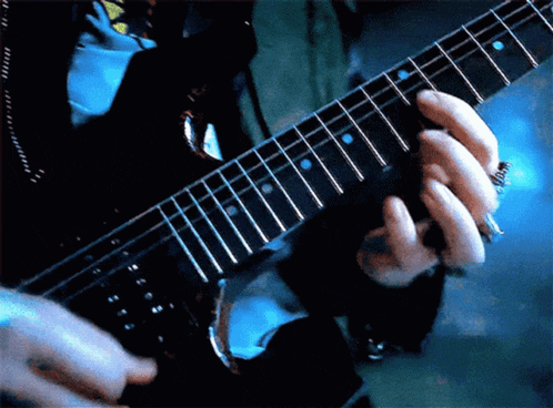 a close up of a person playing a guitar with a blue background