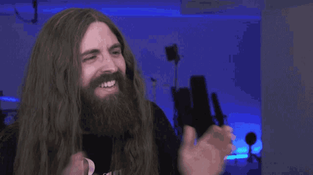a man with long hair and a beard applauds
