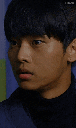 a close up of a young man 's face with his eyes closed and the text hakyungie below him