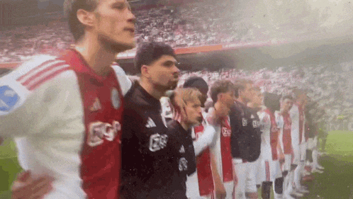 a group of soccer players are standing in a line on the field .