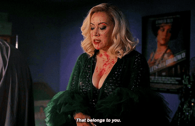 a woman in a green dress with blood on her face says " that belongs to you "