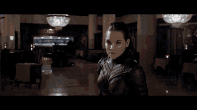 a man and a woman are standing next to each other in a room in a movie .