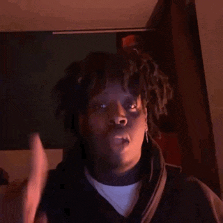 a man with dreadlocks is making a peace sign
