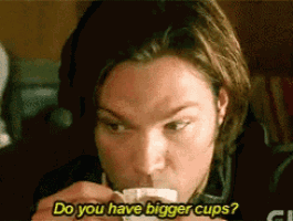 a man is drinking from a cup and asking if he has bigger cups