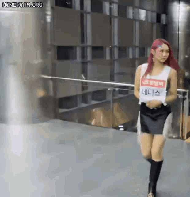 a woman with red hair is walking in front of a building .