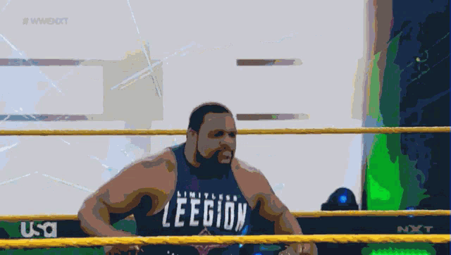 a man in a wrestling ring is wearing a legion shirt