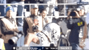 a football player in a white helmet is being photographed by a cameraman .