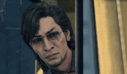 a man with glasses is looking out of a window .