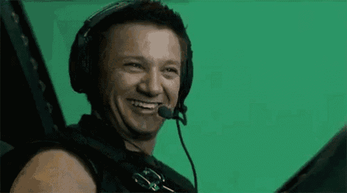 a man wearing headphones and a microphone is smiling and laughing .