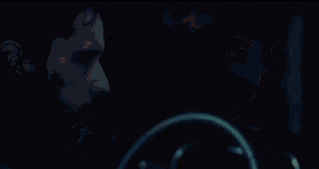 a close up of a person 's face against a dark background