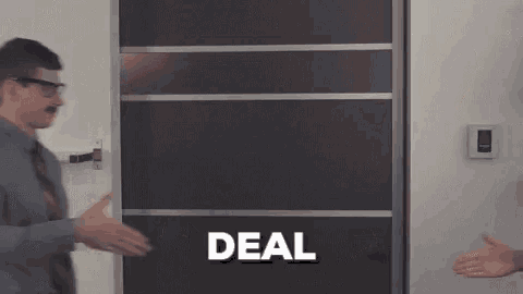 a man in a suit and tie is shaking hands with another man in front of a door with the word deal written on it .