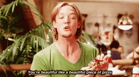 a man in a green shirt is eating a piece of pizza and saying you 're beautiful like a beautiful piece of pizza .