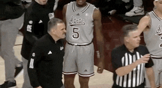a basketball player with the number 5 on his jersey is standing next to a referee