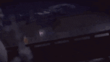 a blurred image of a person standing on a balcony watching a fire .