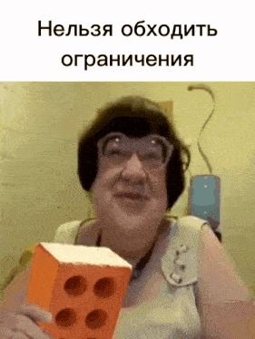a woman wearing glasses is holding an orange brick in her hand