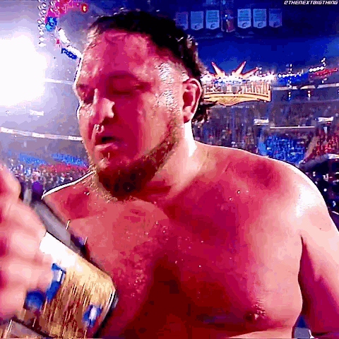 a shirtless wrestler is holding a world heavyweight wrestling championship belt