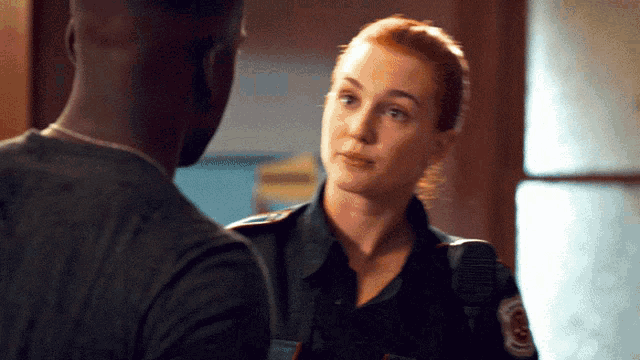 a man and a woman are looking at each other and the woman is wearing a badge that says emergency medical services