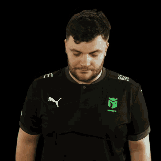 a man with a beard wearing a black shirt with a puma logo on it