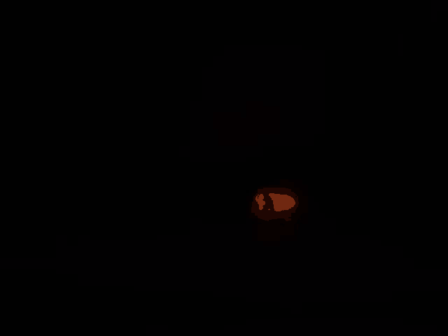 a candle is lit up in the dark with a red flame