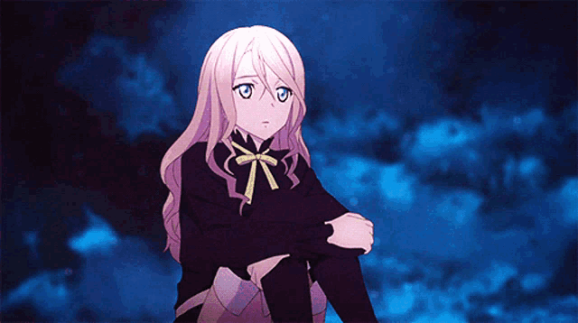 a girl with long blonde hair and blue eyes is sitting on the ground with her arms crossed