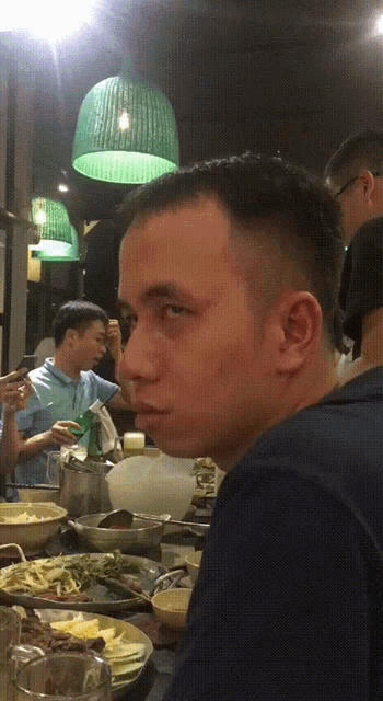 a man is sitting at a table with plates of food