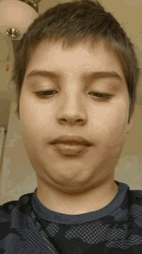 a close up of a boy 's face with a checkered shirt