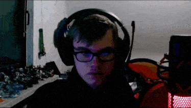 a man wearing headphones and glasses is sitting in front of a computer