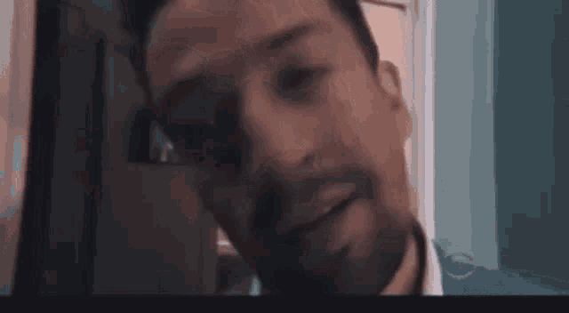 a man is standing in front of a door and looking out .