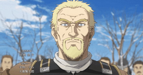 a man with a beard and blue eyes is standing in front of a crowd