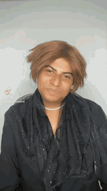 a man is wearing a wig and a pearl necklace .
