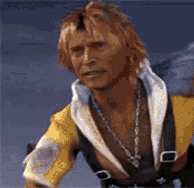 a man with blonde hair and a necklace is wearing a yellow and black jacket .