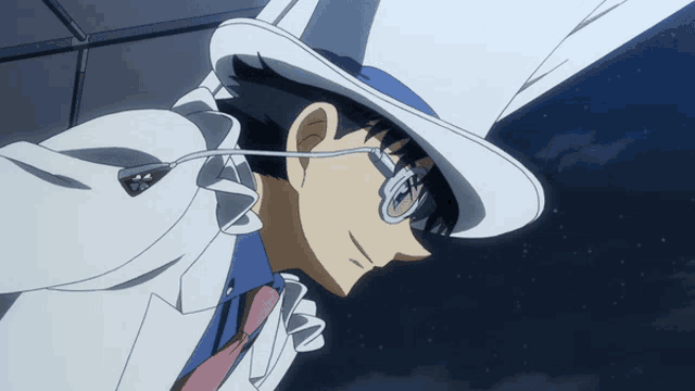 a man wearing a blue hat and glasses looks down