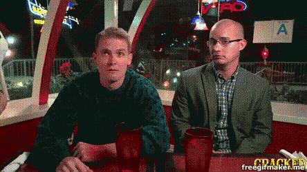 two men sit at a table in front of a sign that says a.