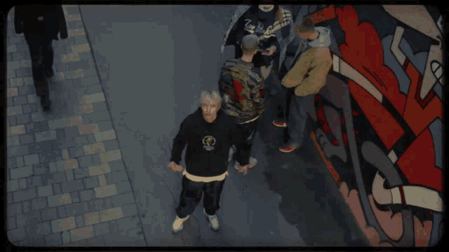 a man wearing a black puma sweatshirt is standing in a crowd