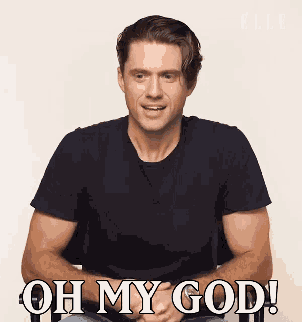a man in a black shirt is sitting in a chair and saying oh my god