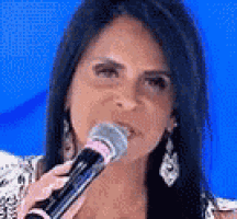 a woman is holding a microphone in front of her face .